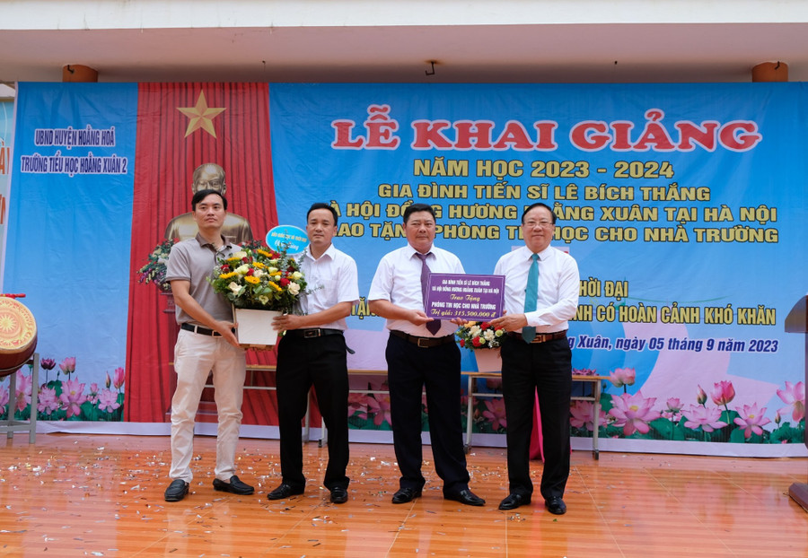 Đại diện Trường Tiểu học Hoằng Xuân 2 đón nhận món quà từ nhà tài trợ. (Ảnh: NT).