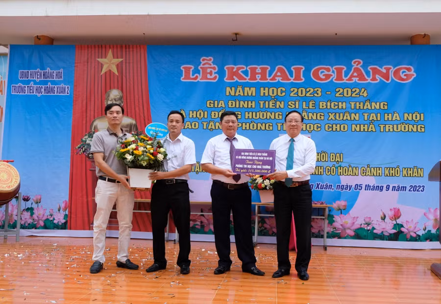 Đại diện Trường Tiểu học Hoằng Xuân 2 đón nhận món quà từ nhà tài trợ. (Ảnh: NT).