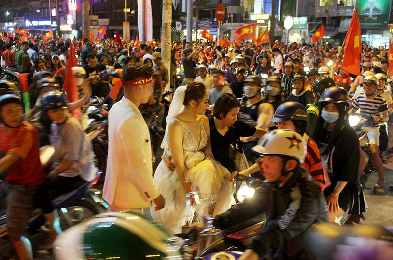  Cô dâu chú rể chụp ảnh cưới giữa “bão” Việt Nam vô địch - ảnh 2