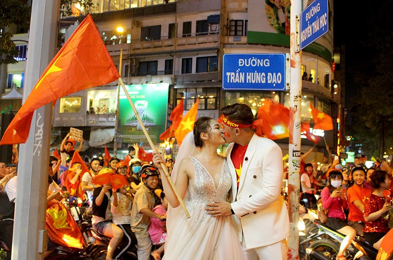  Cô dâu chú rể chụp ảnh cưới giữa “bão” Việt Nam vô địch - ảnh 1