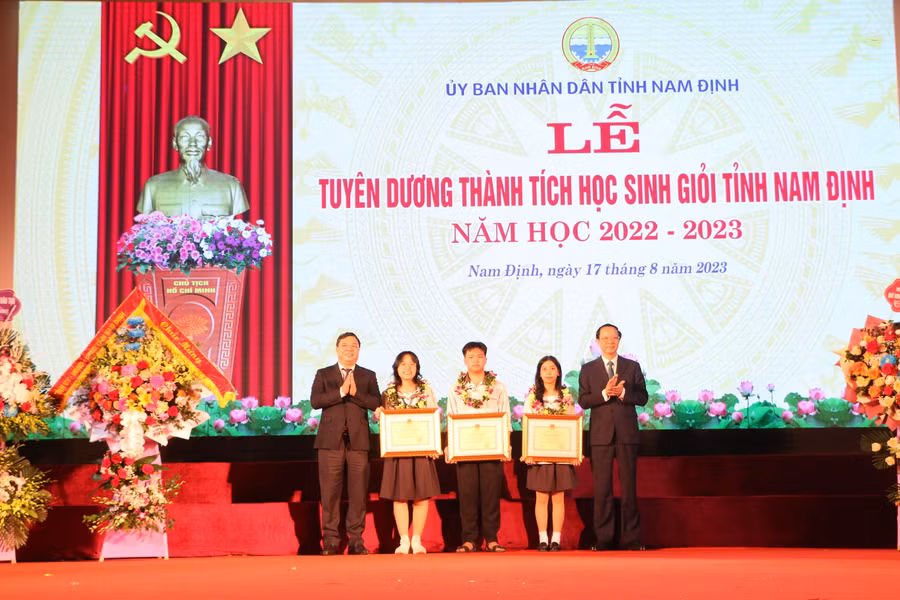 Thứ trưởng Phạm Ngọc Thưởng (bìa phải) và Bí thư Tỉnh ủy Nam Định Phạm Gia Túc tặng Bằng khen của Bộ GD&ĐT cho các em học sinh tiêu biểu xuất sắc của tỉnh Nam Định. 
