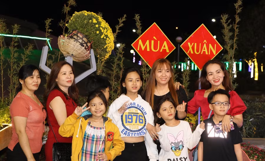 Nhiều bạn trẻ, gia đình súng sính xuống vườn hoa chụp hình để lưu lại những hình ảnh đẹp trong mùa xuân. (Ảnh:Ý Thảo).