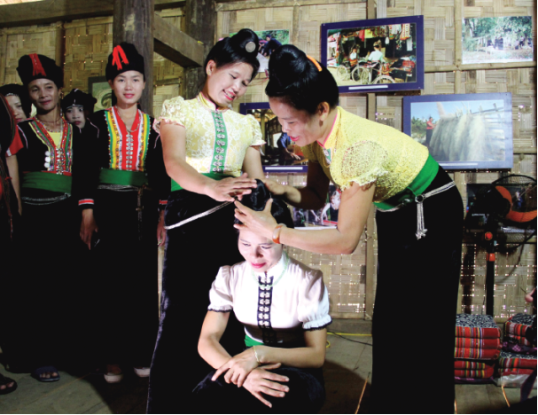 Nghi thức búi tóc ngược của phụ nữ Thái trong lễ tằng cẩu Nghi thức búi tóc ngược của phụ nữ Thái trong lễ tằng cẩu