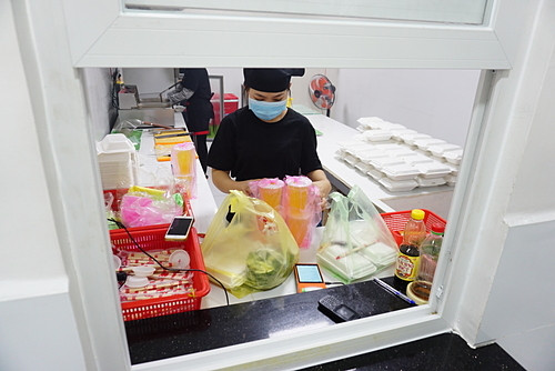 Mô hình bếp chung xuất hiện ở Việt Nam ảnh 1 Một gian bếptrong căn bếp trung tâmtại Thủ Đức nhìn qua ô cửa giao hàng. Ảnh: Viễn Thông