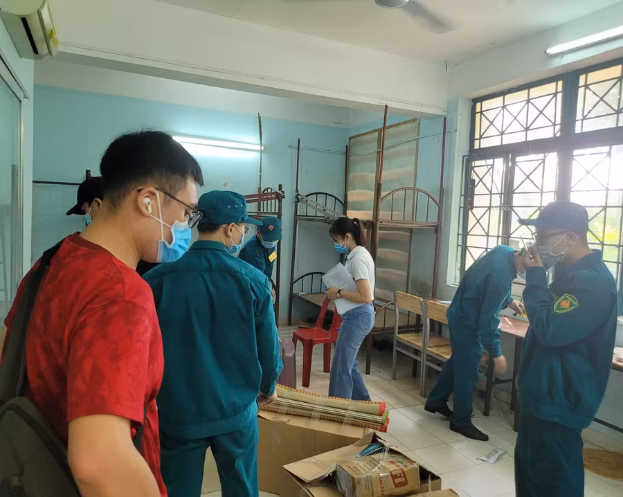 Lực lượng dân quân và tình nguyện viên thu dọn đồ đạc của sinh viên đã về quê tại KTX ĐHQG TPHCM