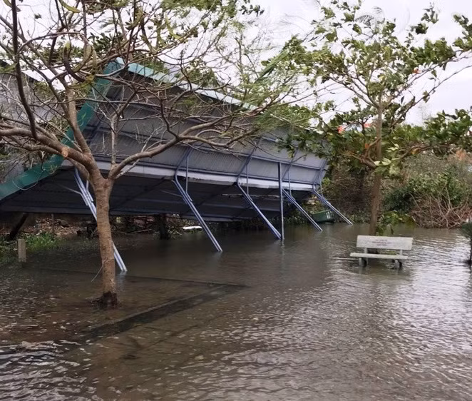 Nhà để xe của trường bị gió mạnh cuốn nằm nghiêng ngả.