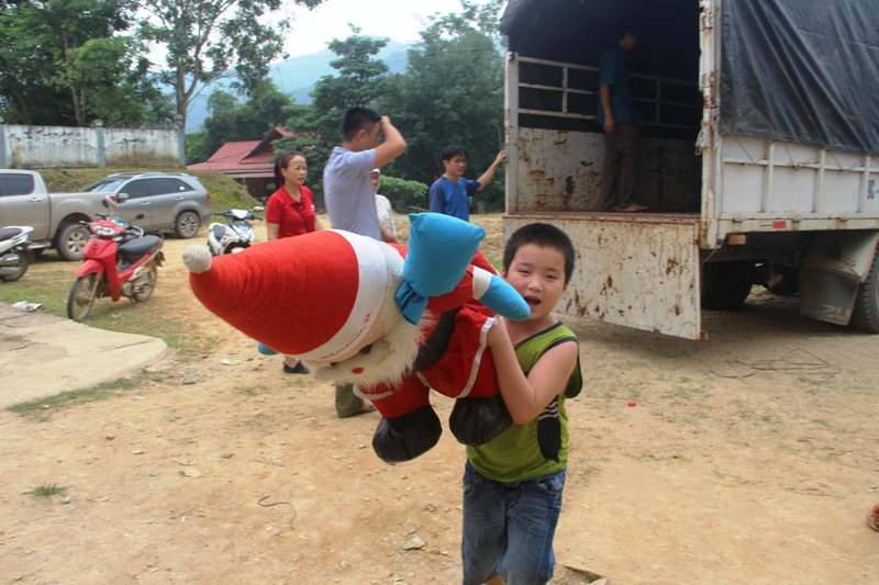 Một em bé vui mừng đón nhận quà từ đoàn từ thiện.