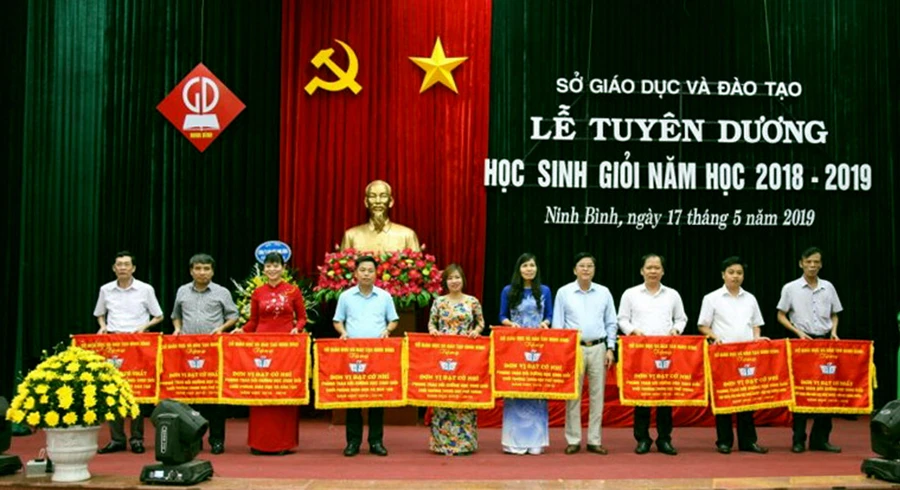 Ông Vũ Văn Kiểm - Giám đốc Sở GD&ĐT Ninh Bình (thứ tư từ phải sang trái) trao tặng cờ thi đua cho các đơn vị có thành tích xuất sắc