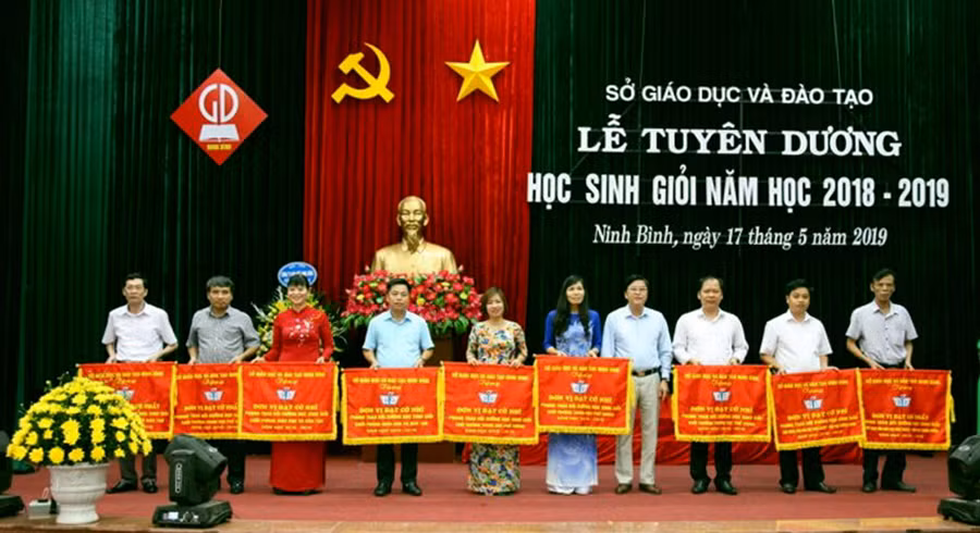 Ông Vũ Văn Kiểm - Giám đốc Sở GD&ĐT Ninh Bình (thứ tư từ phải sang trái) trao tặng cờ thi đua cho các đơn vị có thành tích xuất sắc