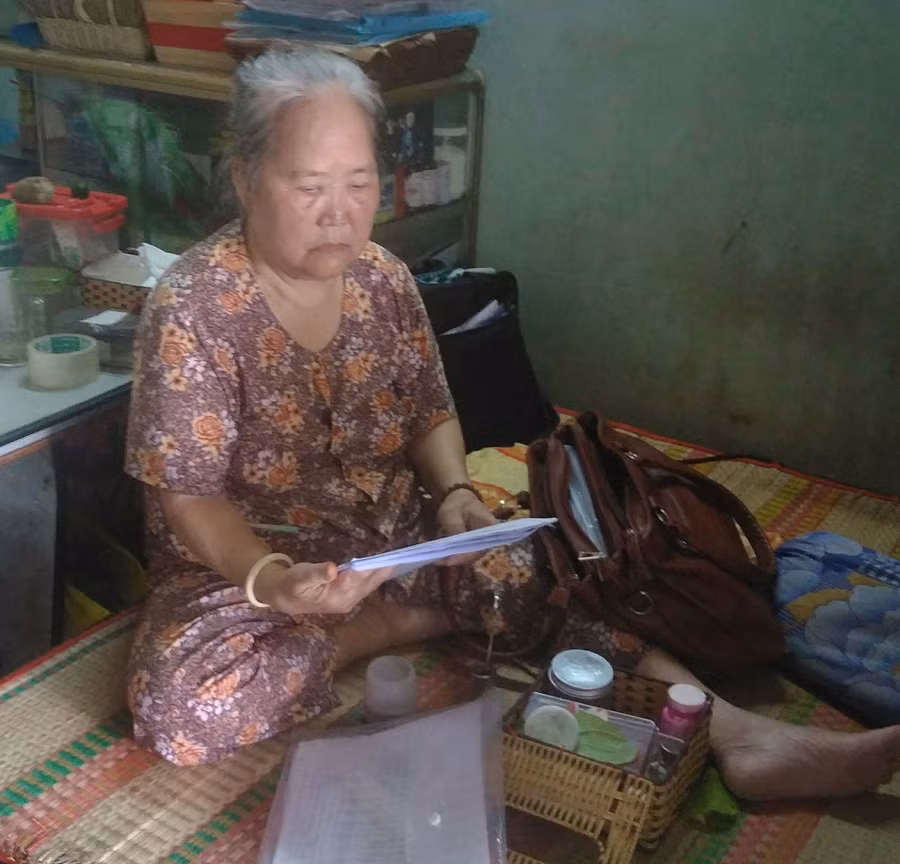 Bà Lê Thị The chuẩn bị tài liệu để gặp lãnh đạo TPHCM