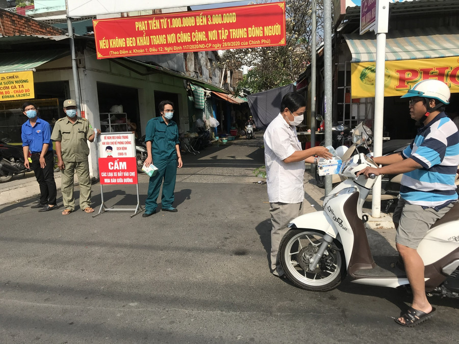 Nhắc nhở các trường hợp không đeo khẩu trang, hoặc đeo không đúng cách tại chợ Mỹ Bình (ảnh CTTĐT An Giang).