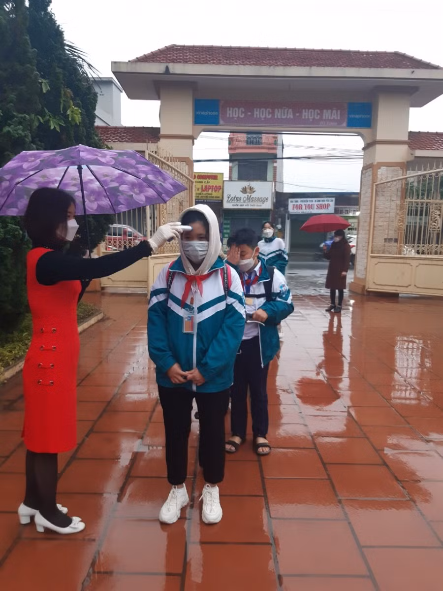 Học sinh Trường THCS Yên Định (Hải Hậu) tới trường trong tiết trời có mưa phùn.