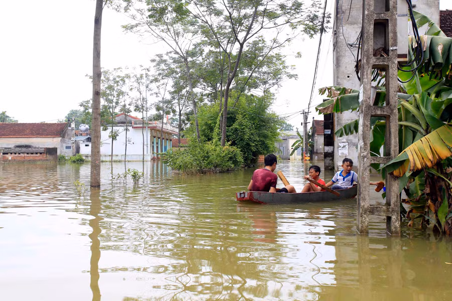 Trẻ em trong làng di chuyển bằng thuyền tới trường