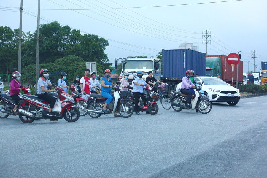 Quốc lộ 5 có mật độ giao thông cao nhưng người dân vẫn phải bất chấp nguy hiểm băng qua đường (ảnh chụp chiều 25/7)