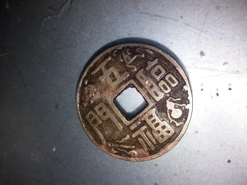 Đồng tiền này được gỡ ra từ phía dưới bụng tượng kim loại. Ảnh: CTV. Đồng tiền này được gỡ ra từ phía dưới bụng tượng kim loại. Ảnh: CTV.