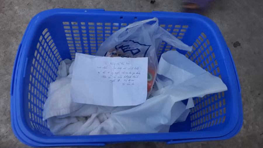 Chiếc giỏ có vài vật dụng cho em bé và tờ giấy của bà mẹ để lại.