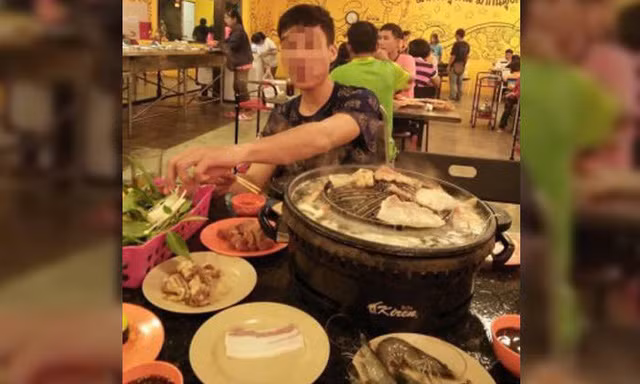 Người đàn ông bị bắt gặp khi đang ngồi ăn chễm chệ tại một nhà hàng lẩu sang trọng sau khi ăn xin trên mạng. (Nguồn: STOMP)