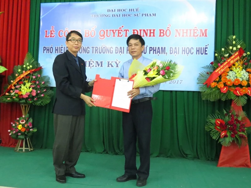 PGS.TS.Nguyễn Quang Linh, Giám đốc Đại học Huế trao Quyết định bổ nhiệm và tặng hoa chúc mừng PGS.TS.Nguyễn Văn Thuận (bên phải)