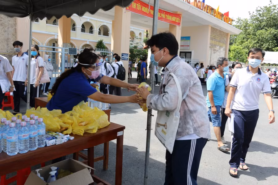 Tình nguyện viên trao nước uống cho thí sinh.