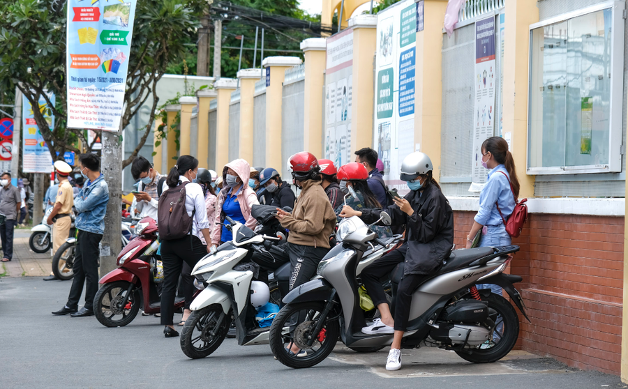 Phụ huynh đứng đợi con ở cổng trường.