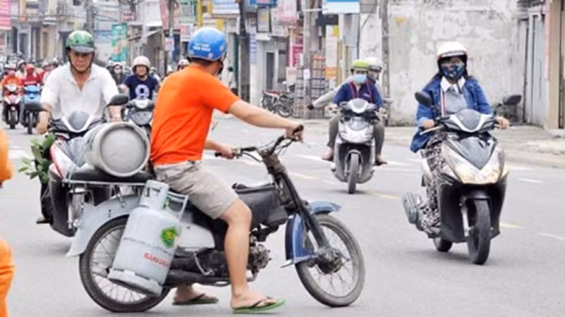 Hình ảnh nhân viên giao gas mặc nhiên “cõng” nhiều bình gas di chuyển trên đường phố đông đúc vẫn thường xuyên xuất hiện.