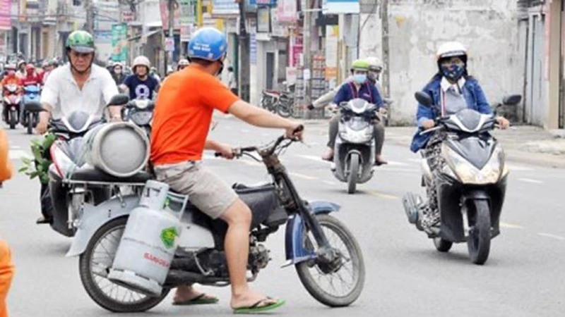 Hình ảnh nhân viên giao gas mặc nhiên “cõng” nhiều bình gas di chuyển trên đường phố đông đúc vẫn thường xuyên xuất hiện.