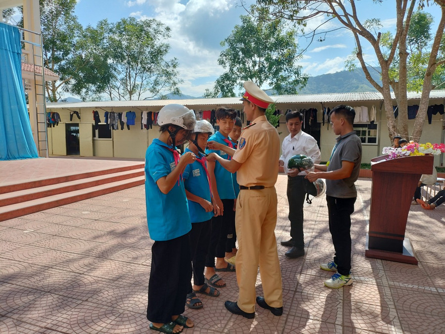 Trao tặng mũ bảo hiểm cho học sinh trong buổi tuyên truyền, phổ biến pháp luật về an toàn giao thông tại trường THCS Nậm Cần, huyện Tân Uyên.
