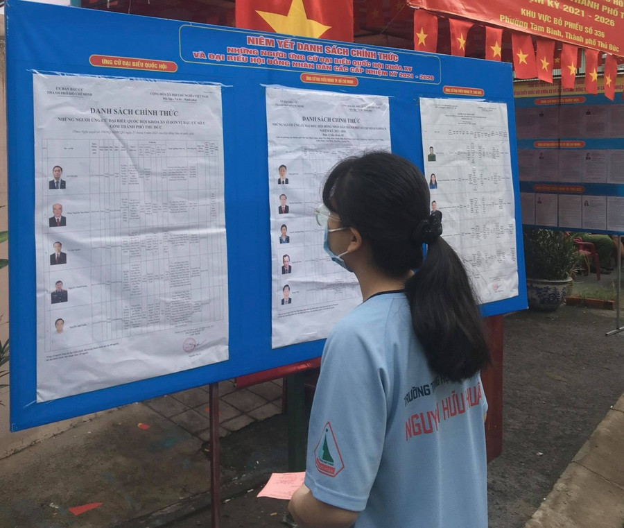Một học sinh THPT tham khảo thông tin ứng viên và chương trình hành động để lựa chọn và bỏ phiếu Một học sinh THPT tham khảo thông tin ứng viên và chương trình hành động để lựa chọn và bỏ phiếu