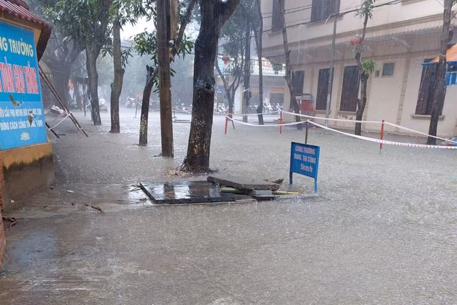 Nước ngập tuyến đường đang thi công dở dang buộc phải cấm người qua lại.