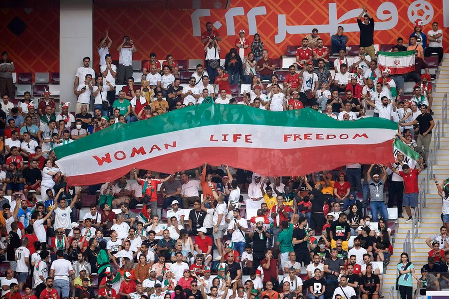 Một tấm quốc kỳ Iran với thông điệp ý nghĩa về đời sống của phụ nữ ở một góc khán đài.