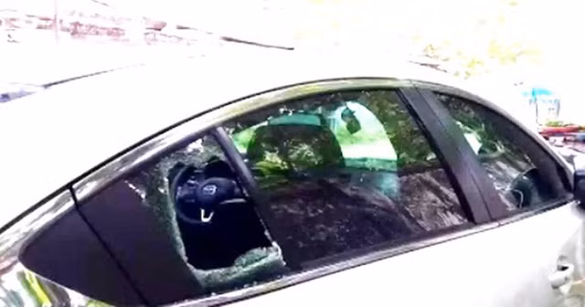  Một chiếc xe ô tô bị kẻ gian đập vỡ kính trước, bên trái để lấy trộm tài sản trong xe ô tô 