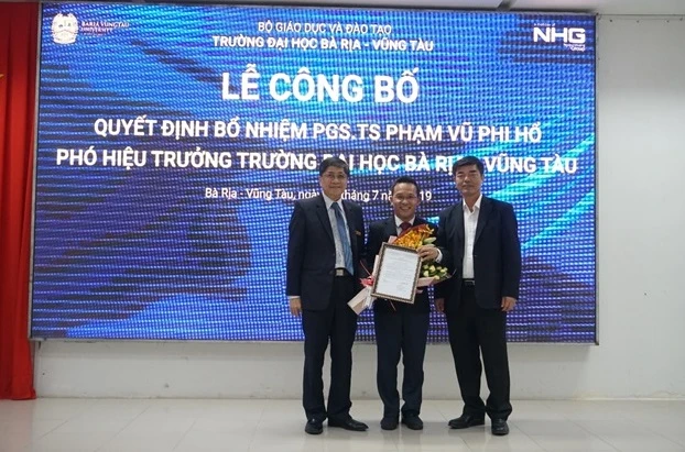 GS.TS Nguyễn Lộc (bên trái), Hiệu trưởng BVU và PGS.TS Thái Bá Cần, Phó Tổng Giám đốc phát triển khối Đại học NHG trao quyết định Phó Hiệu trưởng BVU cho PGS.TS Phạm Vũ Phi Hổ