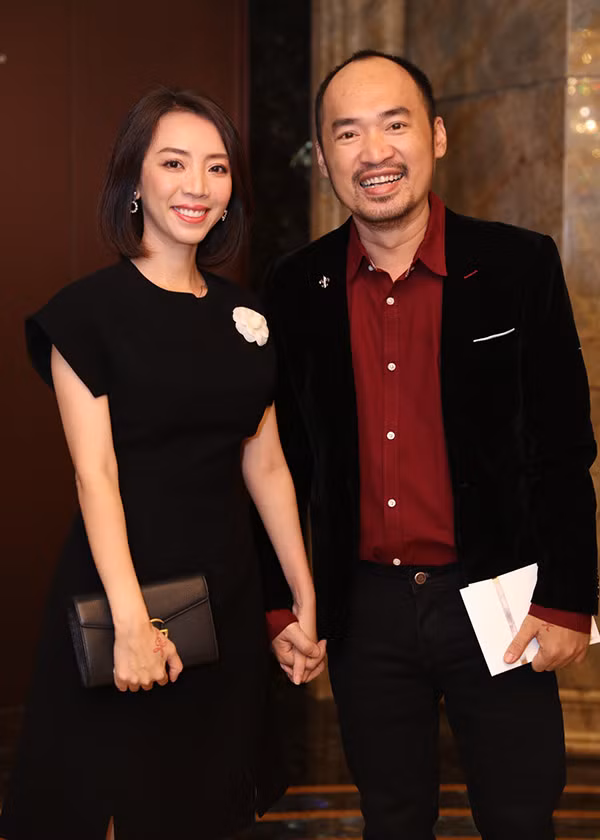 Vợ chồng Thu Trang - Tiến Luật nắm tay nhau không rời.