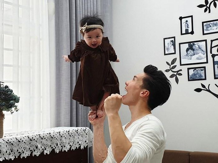 Bé Tâm An rất thích thú khi đứng trên tay bố.