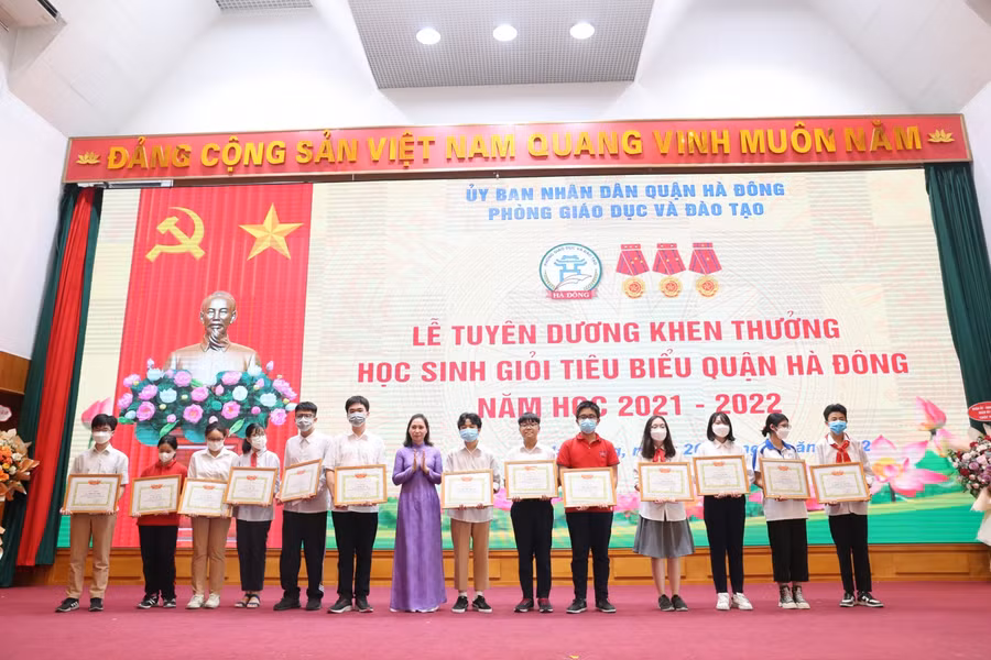 Chủ tịch UBND quận Hà Đông Cấn Thị Việt Hà (thứ 7 từ trái sang) trao thưởng cho học sinh tiêu biểu.