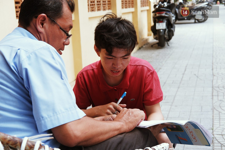 Lớp học đáng yêu trên vỉa hè: Một bác bảo vệ vừa giữ xe vừa dạy chữ cho cậu nhóc bán hàng rong ở Sài Gòn - Ảnh 1. Lớp học đáng yêu trên vỉa hè: Một bác bảo vệ vừa giữ xe vừa dạy chữ cho cậu nhóc bán hàng rong ở Sài Gòn - Ảnh 1.