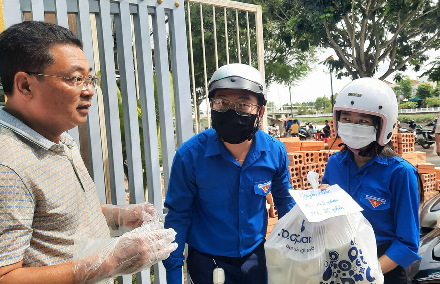 Tình nguyện viên nhận và vận chuyển các suất cơm đến các điểm thi