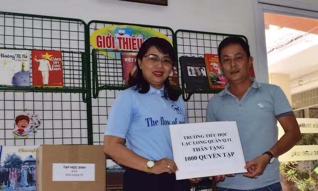 Cô Nguyễn Thị Kim Hương-Hiệu trưởng Trường Tiểu học Lạc Long Quân, Quận 11, TPHCM trao tặng 1.000 quyển tập cho đại diện Báo Giáo dục & Thời đại