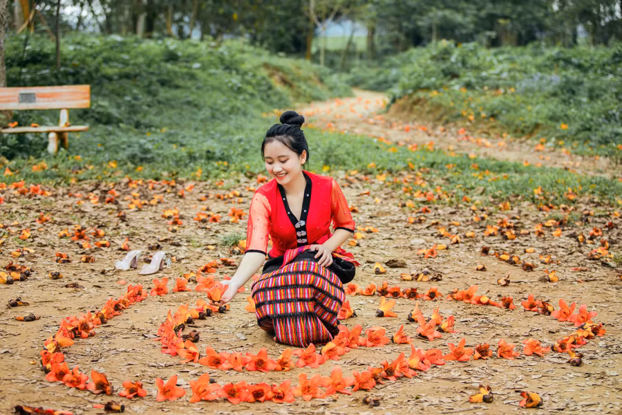 Thiếu nữ tranh thủ chụp hình lưu niệm bên bông hoa Gạo tháng 3.