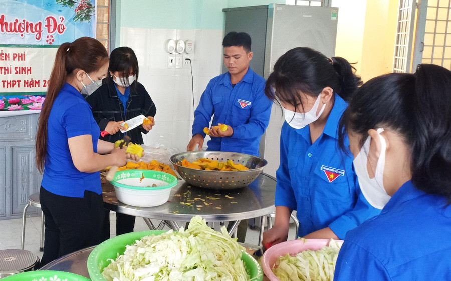 Tình nguyện viên tại huyện Sơn Tây chuẩn bị cơm trưa phục vụ thí sinh và người thân.