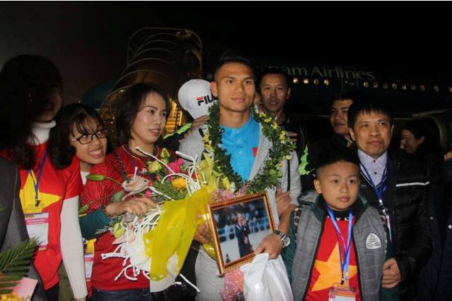 Cầu thủ Xuân Mạnh xuống máy bay trong vòng tay ôm của gia đình