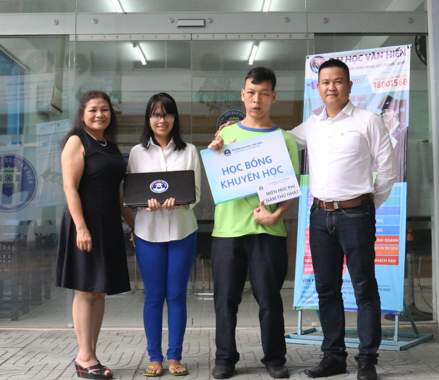 Thạc sĩ Đinh Công Viễn Phương, cùng sinh viên Phan Tích Thiện-sinh viên khuyết tật năm 2 (bên phải) trao quà và động viên Minh Tú khi em đến làm thủ tục nhập học
