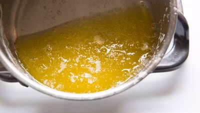 Lúc này bạn hãy đặt nồi nghiêng, bơ sẽ dần chuyển màu vàng trong rất đẹp! Bạn đã tách sữa béo trong bơ thành công rồi đó! Bây giờ chuyển đến công đoạn nổ bắp thôi!