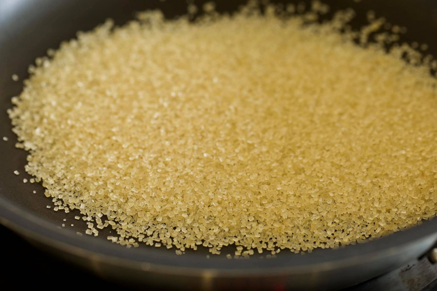 Tự làm nước màu bằng đường vàng, đường kính rất đơn giản. Cho đường vào nồi, chảo. Bật nhiệt lớn cho đường chảy, đừng khua hay động gì vào.