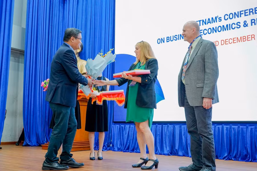 GS Nguyễn Minh Hà, Hiệu trưởng Trường ĐH Mở TPHCM tặng hoa cho các diễn giả.