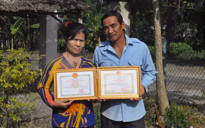 Vợ chồng ông Bùi Văn Vẽ nhận giấy khen của Xã Phương Phú vì đã hiến đất xây trường học