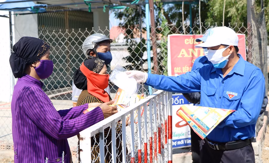 Đoàn viên, thanh niên phát khẩu trang cho bà con nhân dân. (Ảnh: Ý Thảo).