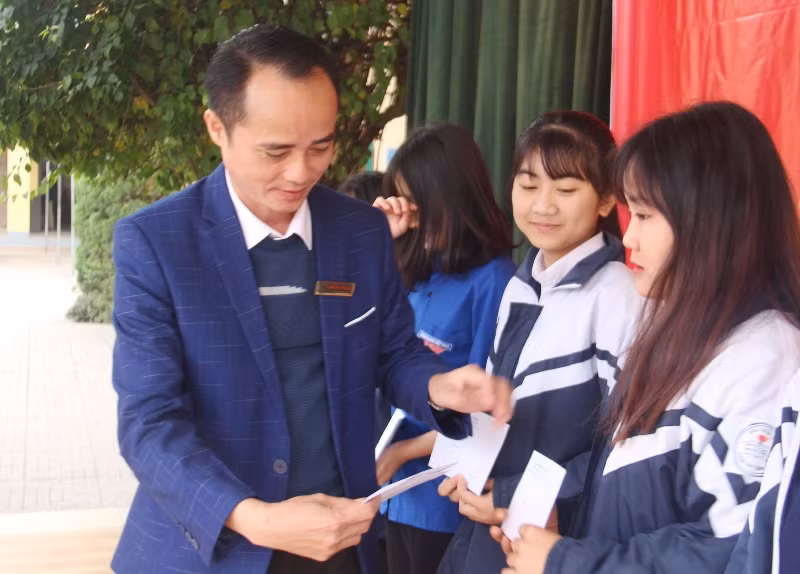 Thầy Nguyễn Văn Quang, Hiệu trưởng Trường THPT Cẩm Bình trao quà cho các em học sinh.