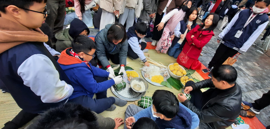 Cha mẹ và học sinh cùng gói bánh chưng Tết gửi tới người nghèo. Cha mẹ và học sinh cùng gói bánh chưng Tết gửi tới người nghèo.