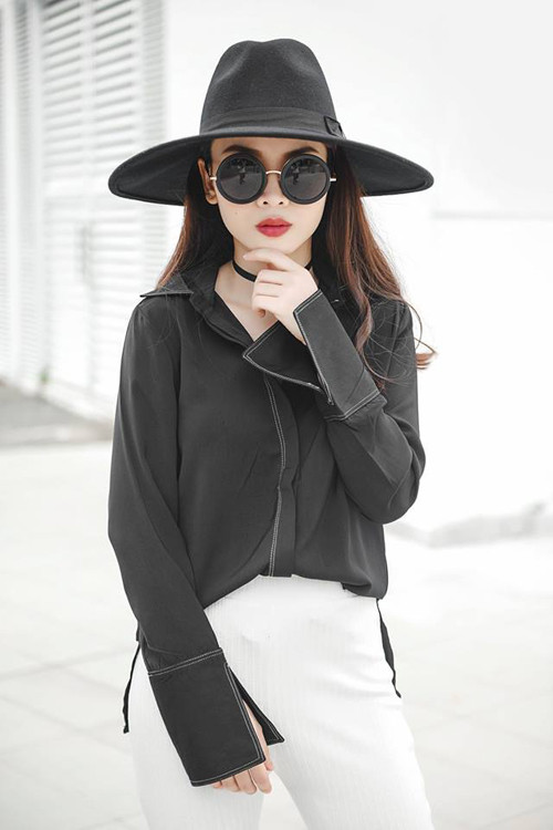 Yến Trang lại chọn sơ mi tay loe tông đen để phối cùng quần Tây trắng, mũ fedora và kính gương tròn sành điệu. dien-so-mi-chat-nhu-sao-viet-2